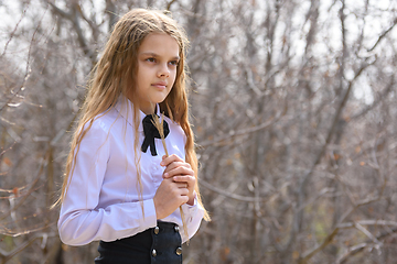 Image showing Portrait of a girl with dried wildflowers in her hands on a forest background