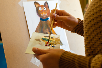 Image showing Portrait of the artist at work, the hands of a girl on a palette with a brush mixes paints