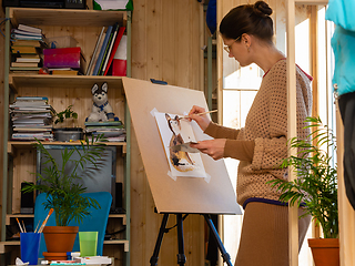 Image showing Girl artist draws on an easel at home