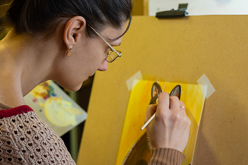 Image showing The artist draws a drawing on an easel, side view, close-up