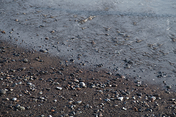 Image showing ocean water on black sand