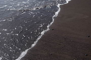 Image showing ocean water on black sand