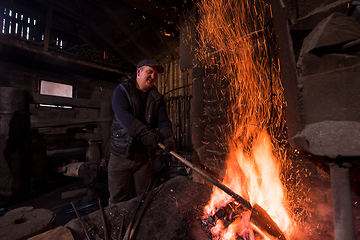 Image showing young traditional Blacksmith working with open fire