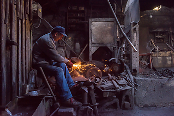 Image showing the blacksmith polishing metal products