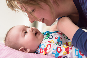 Image showing young mother kissing her cute little baby