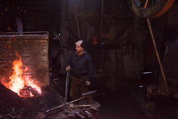 Image showing young traditional Blacksmith working with open fire