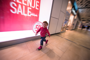Image showing little girl running through shopping mall
