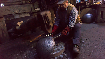 Image showing blacksmith workers using mechanical hammer at workshop