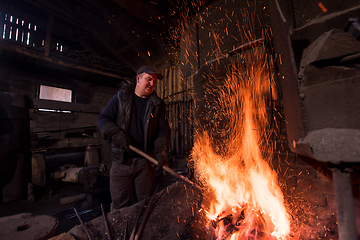 Image showing young traditional Blacksmith working with open fire