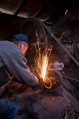 Image showing the blacksmith polishing metal products