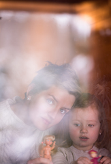 Image showing young mother and little cute daughter playing near the window