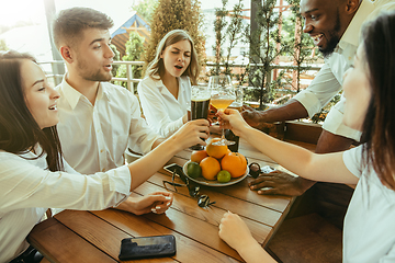 Image showing Young group of friends drinking beer and celebrating together