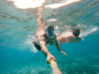 Image showing father and son snorkel in shallow water on coral fish