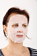 Image showing housewife woman with a sheet mask on her face