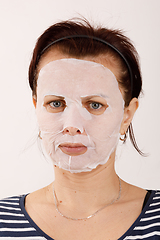 Image showing housewife woman with a sheet mask on her face