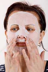 Image showing housewife woman with a sheet mask on her face