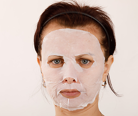 Image showing housewife woman with a sheet mask on her face