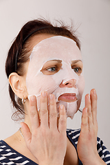 Image showing housewife woman with a sheet mask on her face