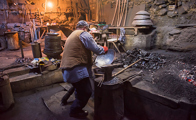 Image showing traditional blacksmith manually forging the molten metal