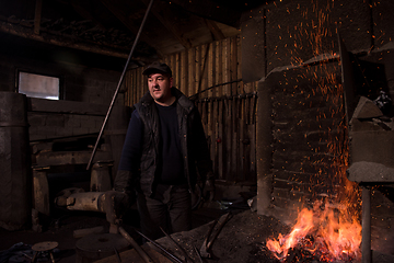 Image showing young traditional Blacksmith working with open fire