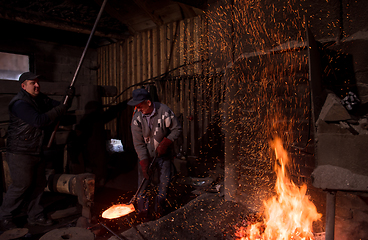 Image showing blacksmith workers using mechanical hammer at workshop