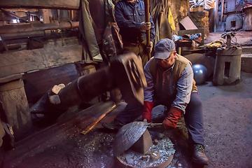 Image showing blacksmith workers using mechanical hammer at workshop