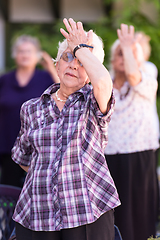 Image showing senior woman exercising with friends