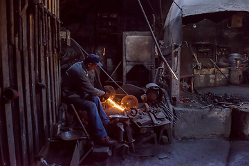 Image showing the blacksmith polishing metal products