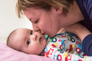 Image showing young mother kissing her cute little baby