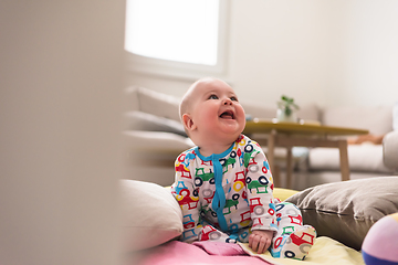 Image showing newborn baby boy sitting on colorful blankets