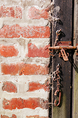 Image showing Rough wood door and brick wall