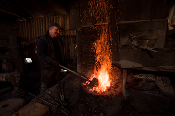 Image showing young traditional Blacksmith working with open fire