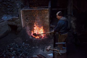 Image showing young traditional Blacksmith working with open fire