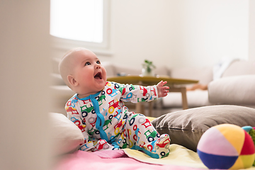 Image showing newborn baby boy sitting on colorful blankets