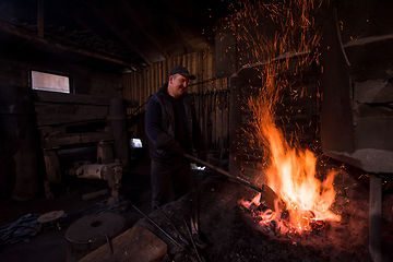 Image showing young traditional Blacksmith working with open fire