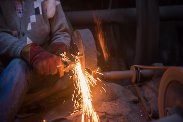 Image showing the blacksmith polishing metal products