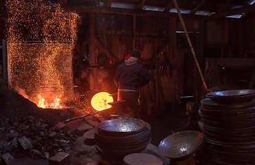 Image showing blacksmith workers using mechanical hammer at workshop