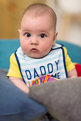 Image showing baby boy sitting between the pillows on sofa