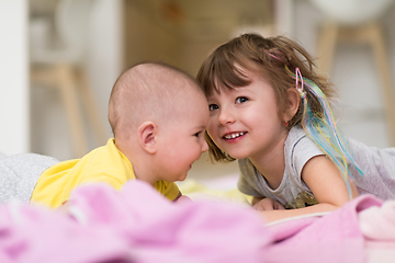 Image showing little sister and her baby brother playing at home