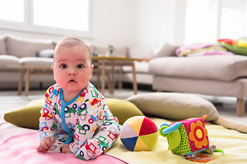 Image showing newborn baby boy sitting on colorful blankets