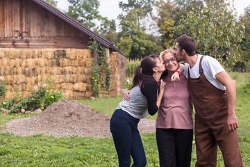 Image showing grandmother being kissed by her lovely adult grandchildren