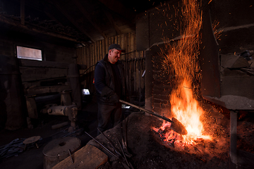 Image showing young traditional Blacksmith working with open fire