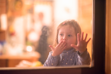 Image showing little cute girl playing near the window