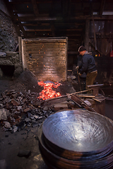 Image showing young traditional Blacksmith working with open fire