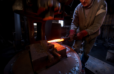 Image showing blacksmith manually forging the molten metal