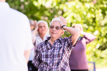 Image showing senior woman exercising with friends