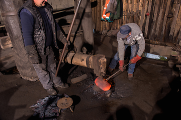 Image showing blacksmith workers using mechanical hammer at workshop