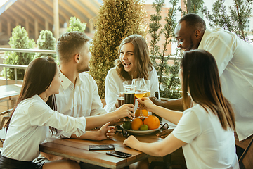 Image showing Young group of friends drinking beer and celebrating together