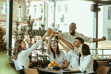 Image showing Young group of friends drinking beer and celebrating together