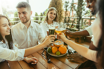 Image showing Young group of friends drinking beer and celebrating together